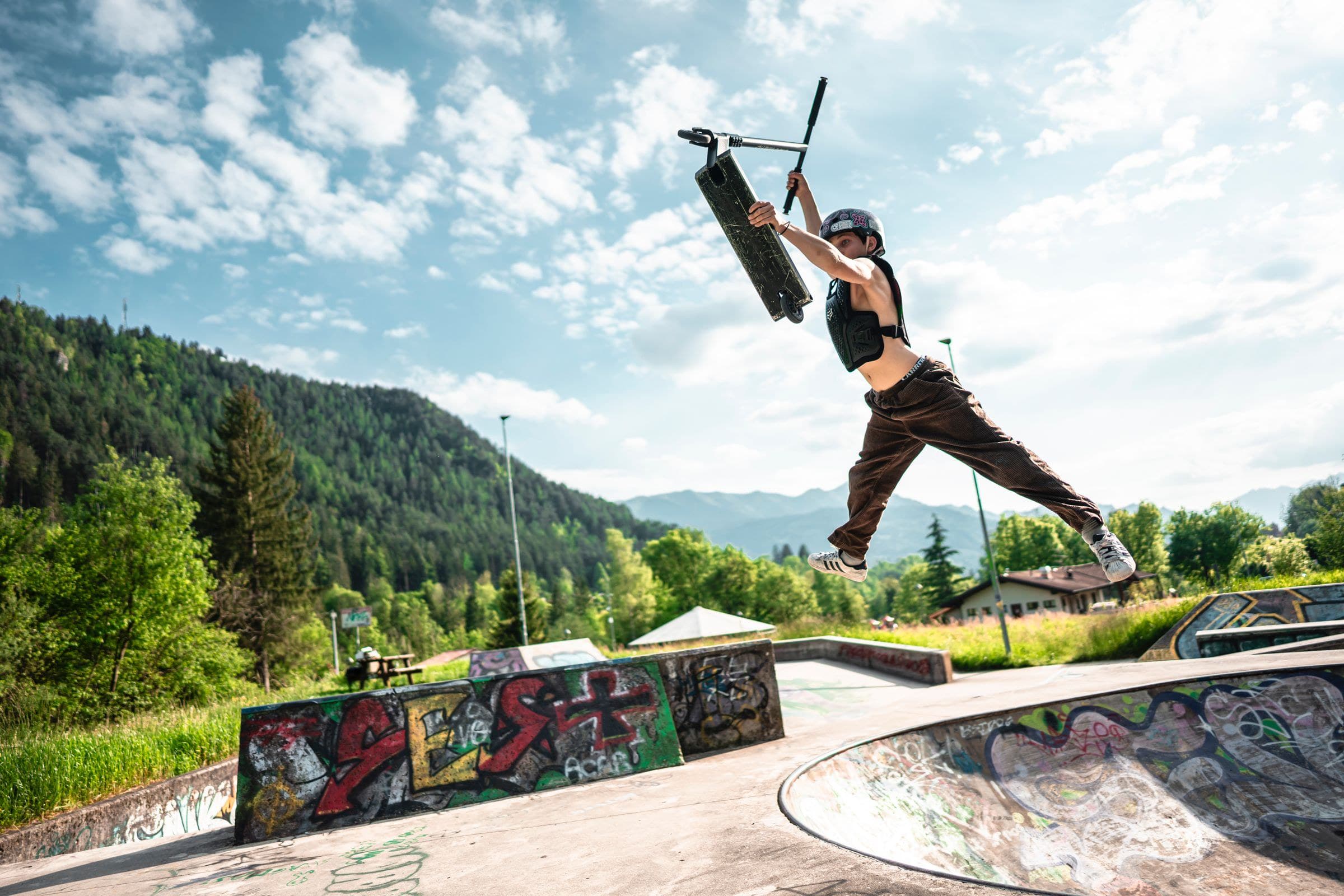 Трюк на самокате в скейт-парке